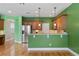 Bright, green kitchen featuring stainless steel appliances, wooden cabinets, and hardwood floors at 1615 Wilson Ave, Orlando, FL 32804