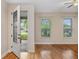 Bright living room featuring gleaming hardwood floors, windows with blinds, and a decorative front door at 1615 Wilson Ave, Orlando, FL 32804