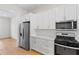 This kitchen features white cabinets and stainless steel appliances at 1919 Sipes Ave, Sanford, FL 32771