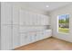 A spacious pantry includes white cabinets with ample storage space and a window at 1919 Sipes Ave, Sanford, FL 32771