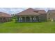 Home back exterior featuring a large green lawn and an open patio with arches at 1929 Sipes Ave, Sanford, FL 32771