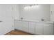 Bathroom with double sink, white cabinets, white walls and wood floor at 1929 Sipes Ave, Sanford, FL 32771