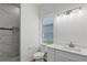 A full bathroom featuring a toilet, a sink, a mirror, a shower with marble tiling and a window at 1929 Sipes Ave, Sanford, FL 32771
