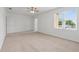 This bedroom has neutral carpet, a ceiling fan and a big window at 1929 Sipes Ave, Sanford, FL 32771