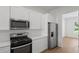 Well-lit kitchen featuring stainless steel appliances, white cabinets, and hardwood flooring at 1929 Sipes Ave, Sanford, FL 32771