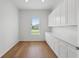 Bright pantry featuring hardwood floors, a window, and plenty of white cabinets with white countertop space at 1929 Sipes Ave, Sanford, FL 32771