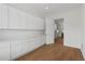 Bright pantry featuring hardwood floors, plenty of white cabinets with white countertop space, and access to the kitchen at 1929 Sipes Ave, Sanford, FL 32771