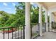 Balcony with black iron railing supported by columns overlooking tree lined street at 2058 Prospect Ave, Orlando, FL 32814
