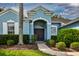 Inviting home entrance with a manicured lawn, and arched front door at 2237 Wintermere Pointe Dr, Winter Garden, FL 34787