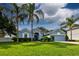 Charming blue home boasts a well-manicured lawn, lush landscaping, and swaying palm trees at 2237 Wintermere Pointe Dr, Winter Garden, FL 34787