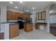 Spacious kitchen with wooden cabinets, black appliances, and an island with gray countertop at 2237 Wintermere Pointe Dr, Winter Garden, FL 34787