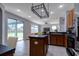 Open kitchen flows into the living area and features an island, stainless steel appliances, and access to the patio at 2237 Wintermere Pointe Dr, Winter Garden, FL 34787