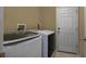 Bright laundry room featuring modern washer and dryer and a white paneled door at 2237 Wintermere Pointe Dr, Winter Garden, FL 34787