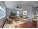 Bright living room with hardwood floors, a ceiling fan, and large windows provides a comfortable gathering space at 2237 Wintermere Pointe Dr, Winter Garden, FL 34787