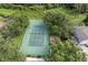 Aerial view of a tennis court and playground surrounded by mature trees within the community at 2237 Wintermere Pointe Dr, Winter Garden, FL 34787