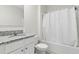 Clean bathroom features a granite-topped vanity, white cabinets, and a shower-tub combo at 2355 White Lilly Dr, Kissimmee, FL 34747