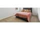 Modern bedroom featuring a sleek platform bed with an orange quilted comforter and chevron pillows at 2355 White Lilly Dr, Kissimmee, FL 34747