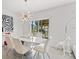 Bright dining area showcasing a modern chandelier, white table set, and view of the backyard at 2355 White Lilly Dr, Kissimmee, FL 34747