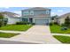 Charming two-story home with a well-maintained lawn, complemented by a paved driveway and lush greenery at 2355 White Lilly Dr, Kissimmee, FL 34747