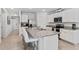 Bright kitchen featuring white cabinets, stainless steel appliances, and a large island with granite countertops at 2355 White Lilly Dr, Kissimmee, FL 34747