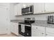 Modern kitchen with stainless steel appliances, granite countertops, and white cabinetry at 2355 White Lilly Dr, Kissimmee, FL 34747