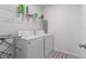 Clean and functional laundry room featuring a washer, dryer, storage shelves, and neutral decor at 2355 White Lilly Dr, Kissimmee, FL 34747