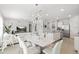 Open-concept living space with white furniture, modern decor, and a dining area leading to the kitchen at 2355 White Lilly Dr, Kissimmee, FL 34747