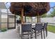 Tiki-style outdoor kitchen featuring a built-in grill, bar seating, and a shaded roof at 2355 White Lilly Dr, Kissimmee, FL 34747