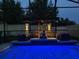 An impressive pool at night with lights, seating, and landscaping at 2355 White Lilly Dr, Kissimmee, FL 34747