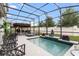 Screened-in pool area with a Buddha statue, tropical plants, and inviting lounge chairs at 2355 White Lilly Dr, Kissimmee, FL 34747