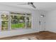 Bright living room with large windows, wood floors, and a white front door, showcasing ample natural light at 241 Brittany Ave, Port Orange, FL 32127