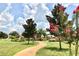 Neighborhood green space featuring a walking path, manicured lawn and flowering trees on a sunny day at 2546 Oneida Loop, Kissimmee, FL 34747