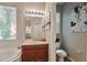 Bright bathroom featuring a sink with wooden cabinets, a toilet, and natural light at 2579 Woodside Ridge Dr, Apopka, FL 32712