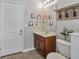 Bathroom featuring a sink with wooden cabinets, a toilet, and decorative wall art at 2579 Woodside Ridge Dr, Apopka, FL 32712