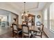 Formal dining room with hardwood floors, coffered ceiling, and elegant chandelier at 2579 Woodside Ridge Dr, Apopka, FL 32712