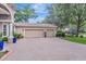 Spacious three-car garage with brick driveway and well-maintained landscaping at 2579 Woodside Ridge Dr, Apopka, FL 32712