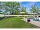 Inviting backyard oasis with a sparkling pool, lush lawn, and charming patio seating area perfect for outdoor relaxation at 2579 Woodside Ridge Dr, Apopka, FL 32712