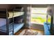 Cozy bedroom with bunk beds, bright decor, and a view of the outdoor landscaping at 2650 Autumn Creek Cir, Kissimmee, FL 34747