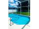 Sparkling in-ground pool featuring a screened enclosure and well-maintained landscaping at 2650 Autumn Creek Cir, Kissimmee, FL 34747