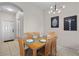 Bright dining room with a wooden table set for six and modern lighting at 2717 Camaro Dr, Kissimmee, FL 34746