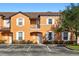 Inviting two-story condo featuring a peach exterior, white-framed windows, and a well-maintained front landscape at 2717 Camaro Dr, Kissimmee, FL 34746