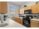 Efficient kitchen design with ample counter space, oak cabinets, and modern black appliances at 2717 Camaro Dr, Kissimmee, FL 34746