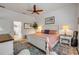 Bright bedroom features a ceiling fan, a large window, and a patterned area rug over white flooring at 3017 Glin Cir, Ormond Beach, FL 32174