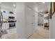 Bright hallway with white walls and tile floors leading to the kitchen and front entry at 3017 Glin Cir, Ormond Beach, FL 32174