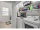 Functional laundry area with washer, dryer, and storage shelving at 3017 Glin Cir, Ormond Beach, FL 32174