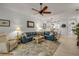 Bright living room features a ceiling fan, neutral paint, and an area rug over white flooring at 3017 Glin Cir, Ormond Beach, FL 32174