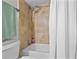 This bathtub with shower includes neutral tile, a white shower curtain, and shower head at 308 N Shadowbay Blvd # 214, Longwood, FL 32779
