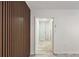 Hallway with decorative wood paneling and tile flooring leads to a light-filled room with a turquoise door at 320 Eaton St, Maitland, FL 32751