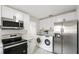 Well-equipped kitchen with stainless steel appliances, modern cabinetry, and convenient laundry area at 320 Eaton St, Maitland, FL 32751