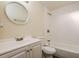 Bright bathroom features a white vanity, round mirror, and combined shower and tub with white tile surround at 3312 Victory Palm Dr, Edgewater, FL 32141